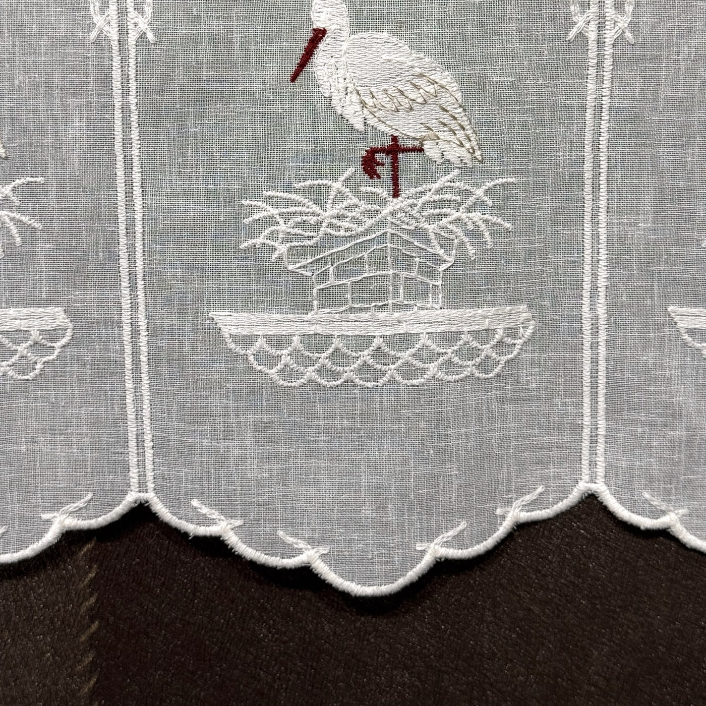 Détail de la broderie du brise-bise cigogne