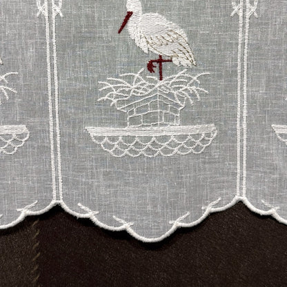 Détail de la broderie du brise-bise cigogne