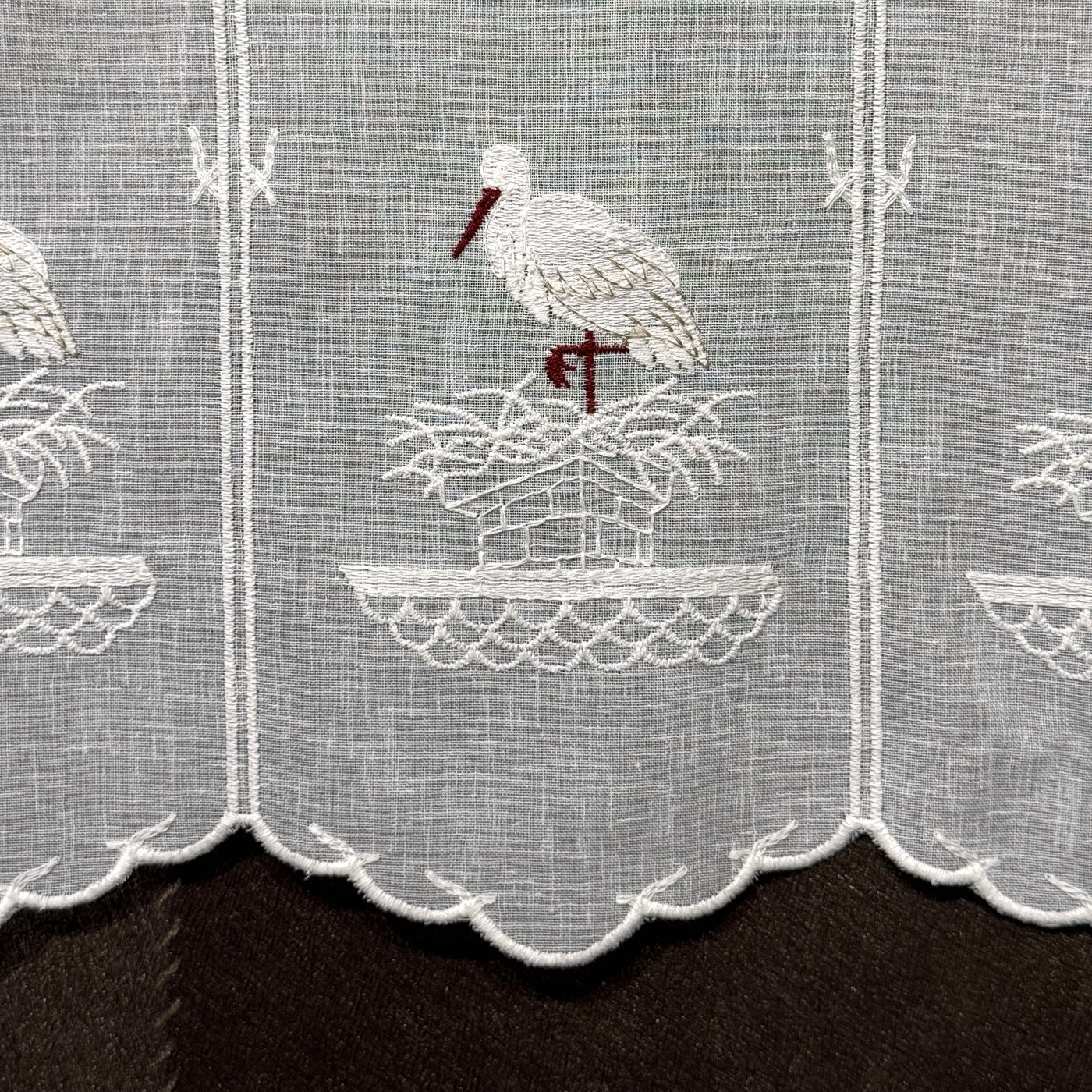 Détail de la broderie du brise-bise cigogne