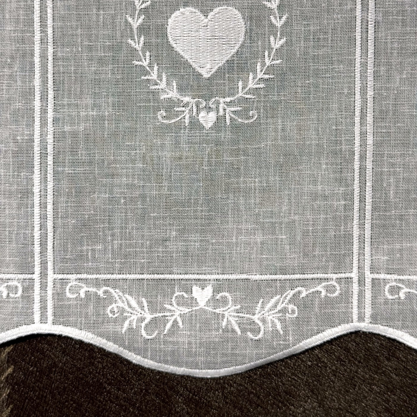 Détail de la broderie du brise-bise cœur en couronne blanc