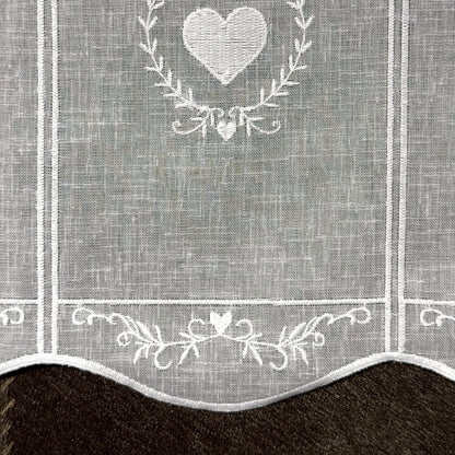 Détail de la broderie du brise-bise cœur en couronne blanc