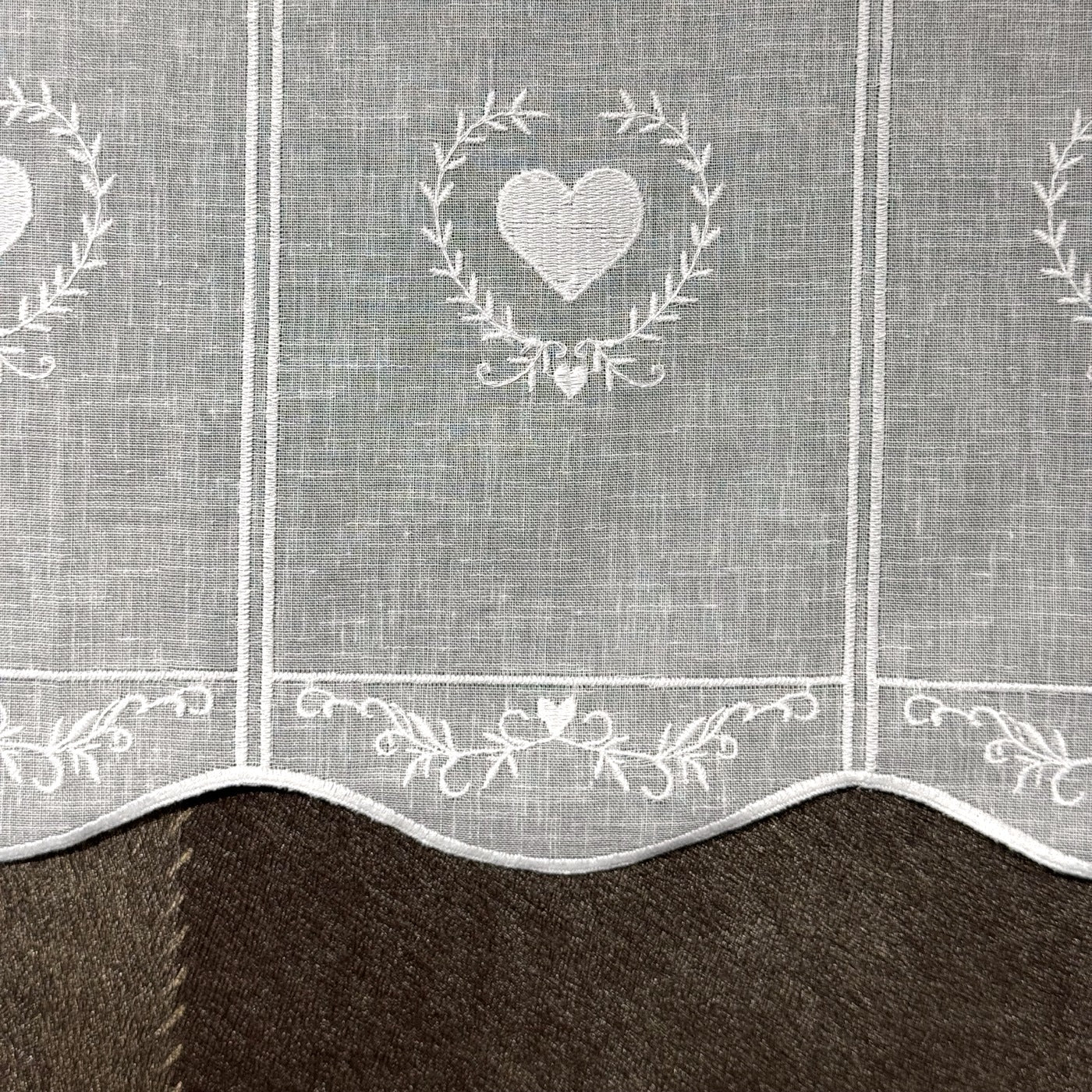 Détail de la broderie du brise-bise cœur en couronne blanc