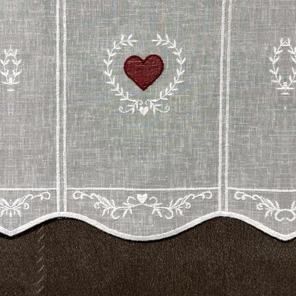 Détail de la broderie du brise-bise cœur en couronne rouge