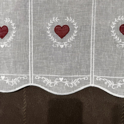 Détail de la broderie du brise-bise cœur en couronne rouge