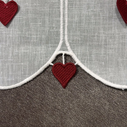 Détail de la broderie du brise-bise cœur filigrane et pampilles