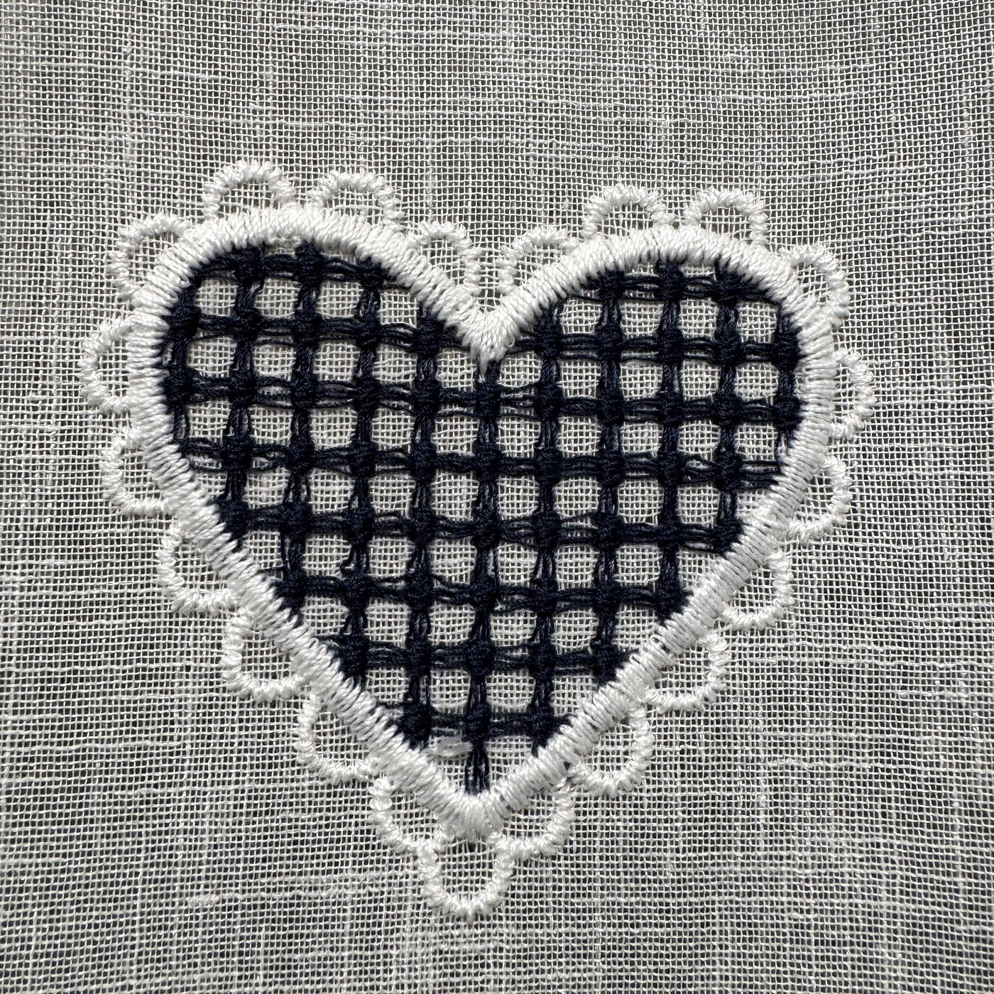 Détail de la broderie du brise-bise cœur vichy bleu