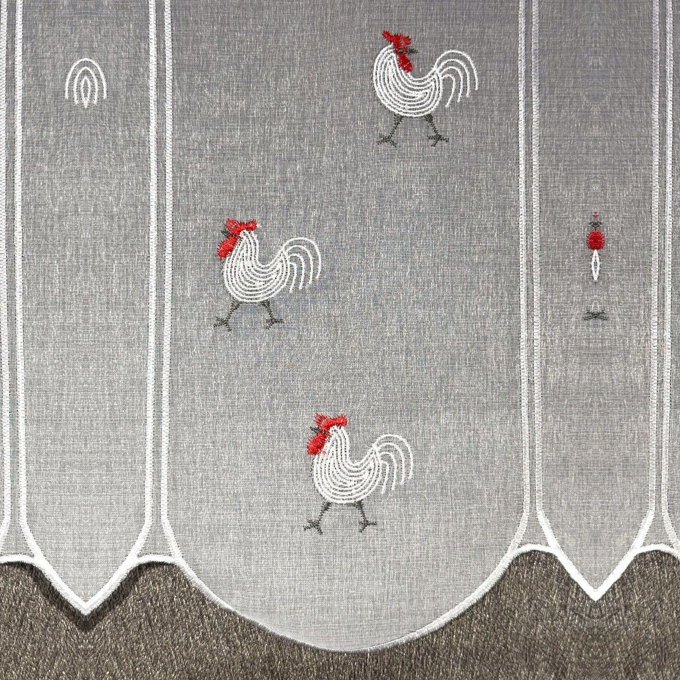 Détail de la broderie du brise-bise coq