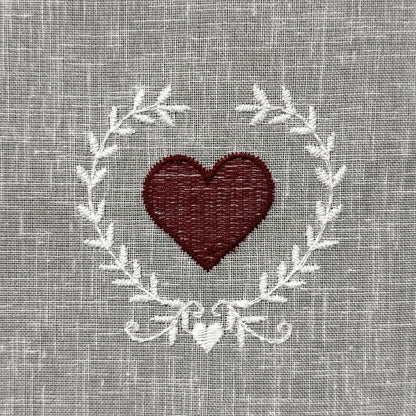 Gros plan du motif brodé du brise-bise cœur en couronne rouge
