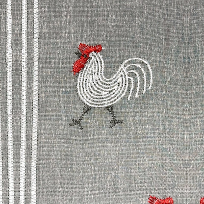 Gros plan du motif brodé du brise-bise coq